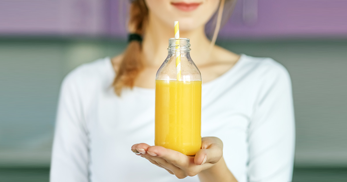 Unhealthy Health Foods to Avoid woman holding a bottle of fruit juice